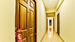 Pasillo de hotel con una puerta de madera con la etiqueta '105' y un letrero rojo de 'No molestar'.