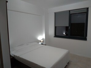 A small, single-bed room with a window, a bedside lamp, and a door. - 2 Appartments , Next to Each Other, on the Beach, Splendid View, max 12 Persons (Navodari)