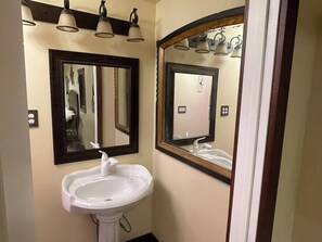 A bathroom with a white sink, two mirrors, and overhead lighting. - Dusty Rose The Wild West 40 Homestead (Cane Beds)