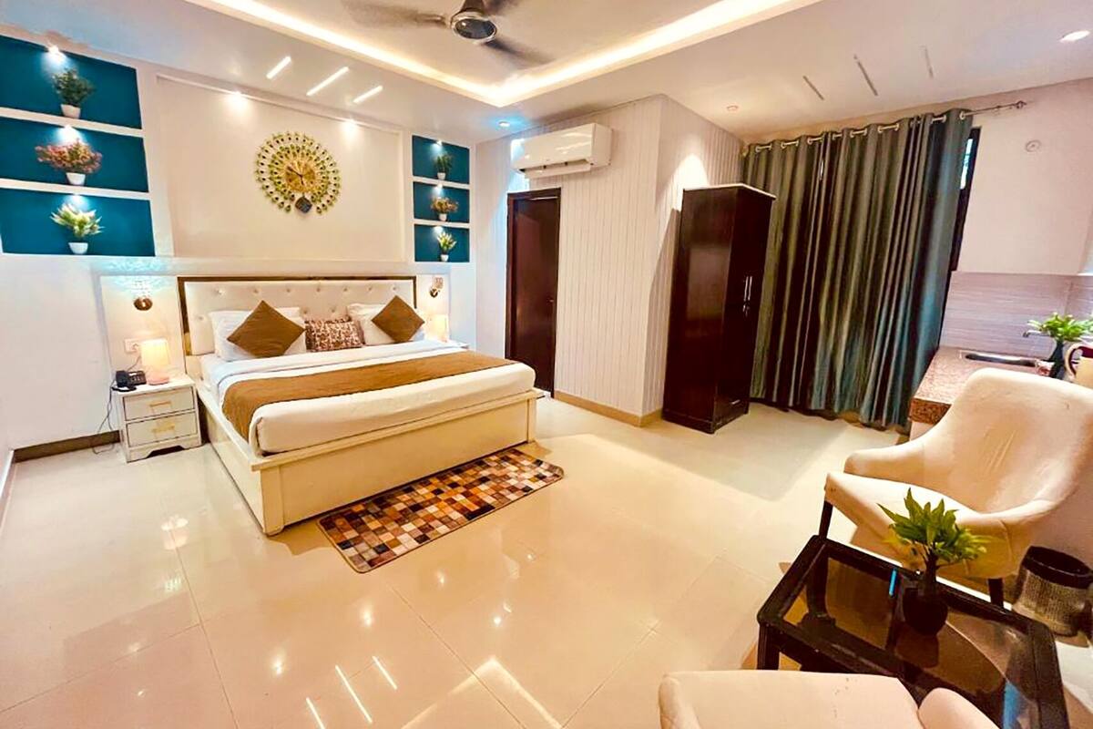 Une chambre moderne avec un grand lit, un ventilateur de plafond, un bureau et une chaise.