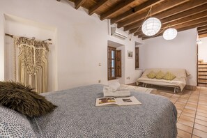 Un dormitorio con cama, ventana, puerta y ventilador de techo.