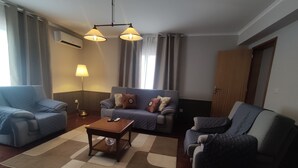 A living room with two sofas, a coffee table, and a lamp. - Blue Almance - T2 Apartment (São João)