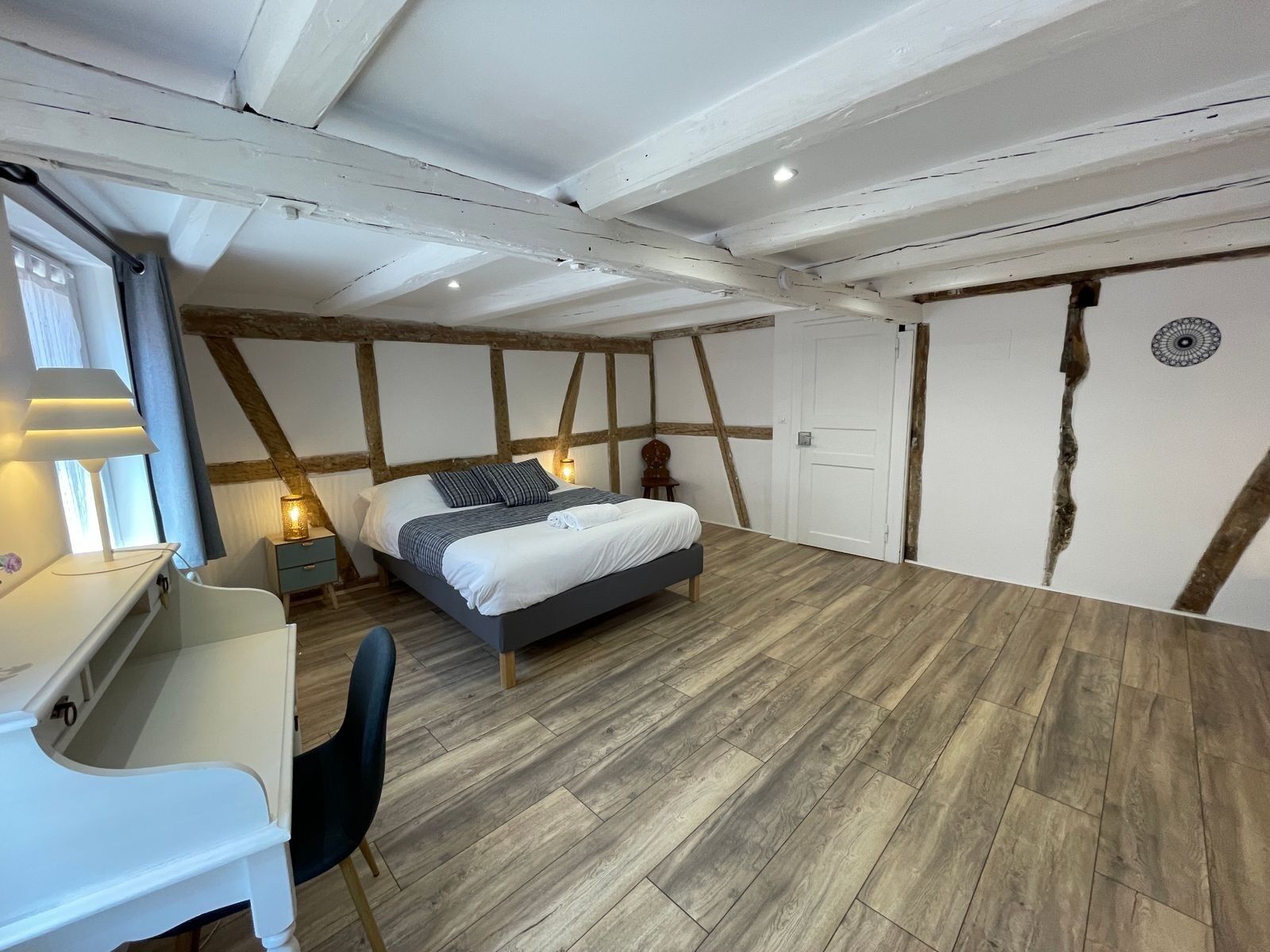 Un dormitorio con una cama, un escritorio y una silla.