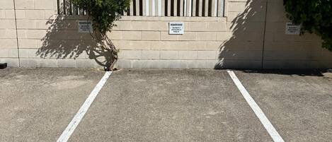 A parking area with a sign indicating reserved parking for block 3, floors 1-3, and a parking space marked with the number 33.