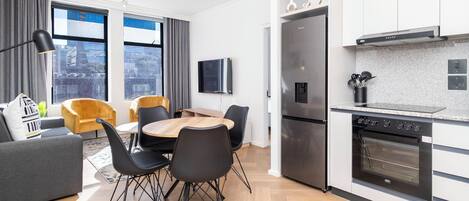 Un appartement moderne comprenant un coin repas, une cuisine et un espace de vie.