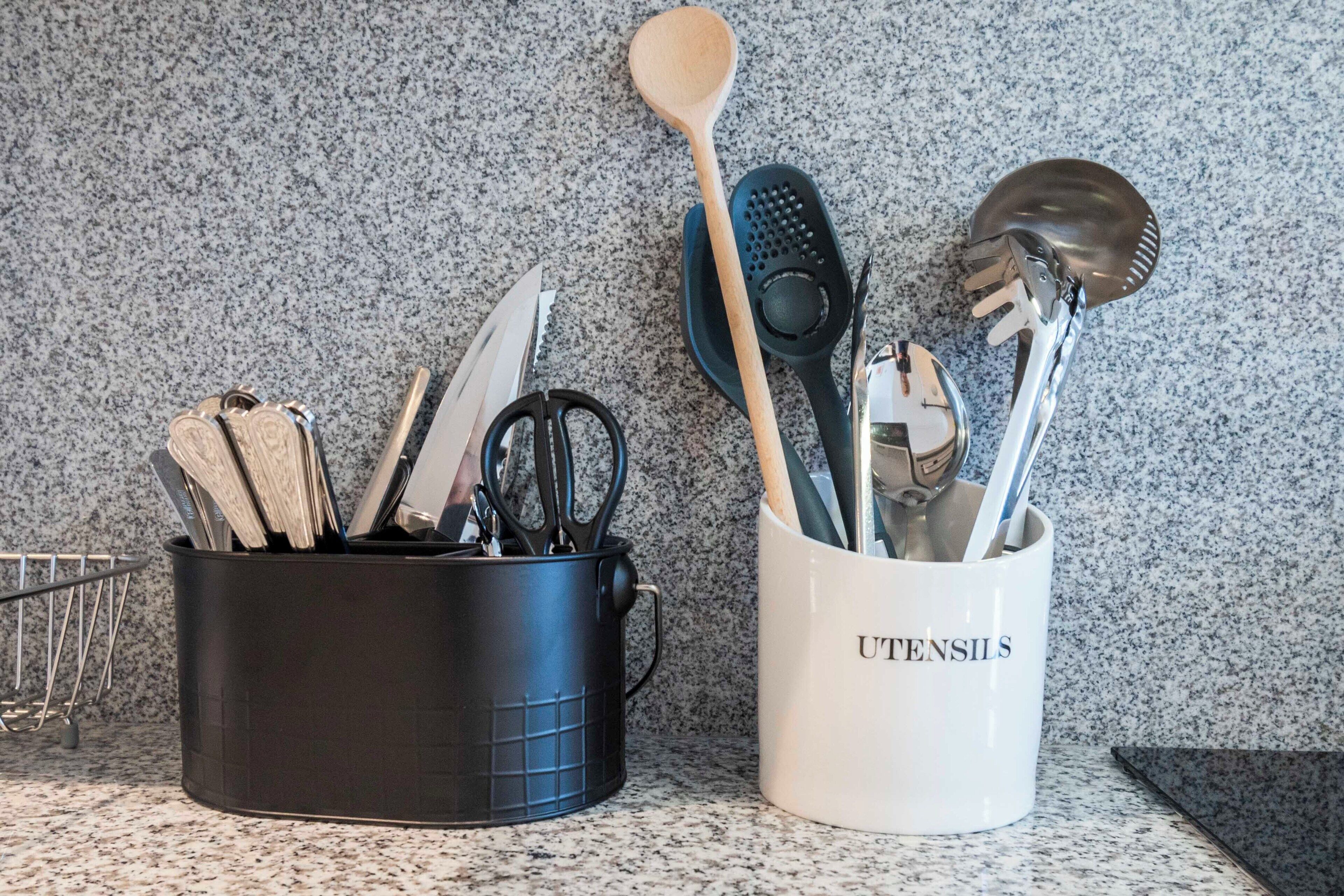 Un piano di lavoro in cucina con utensili e una tazza da caffè.