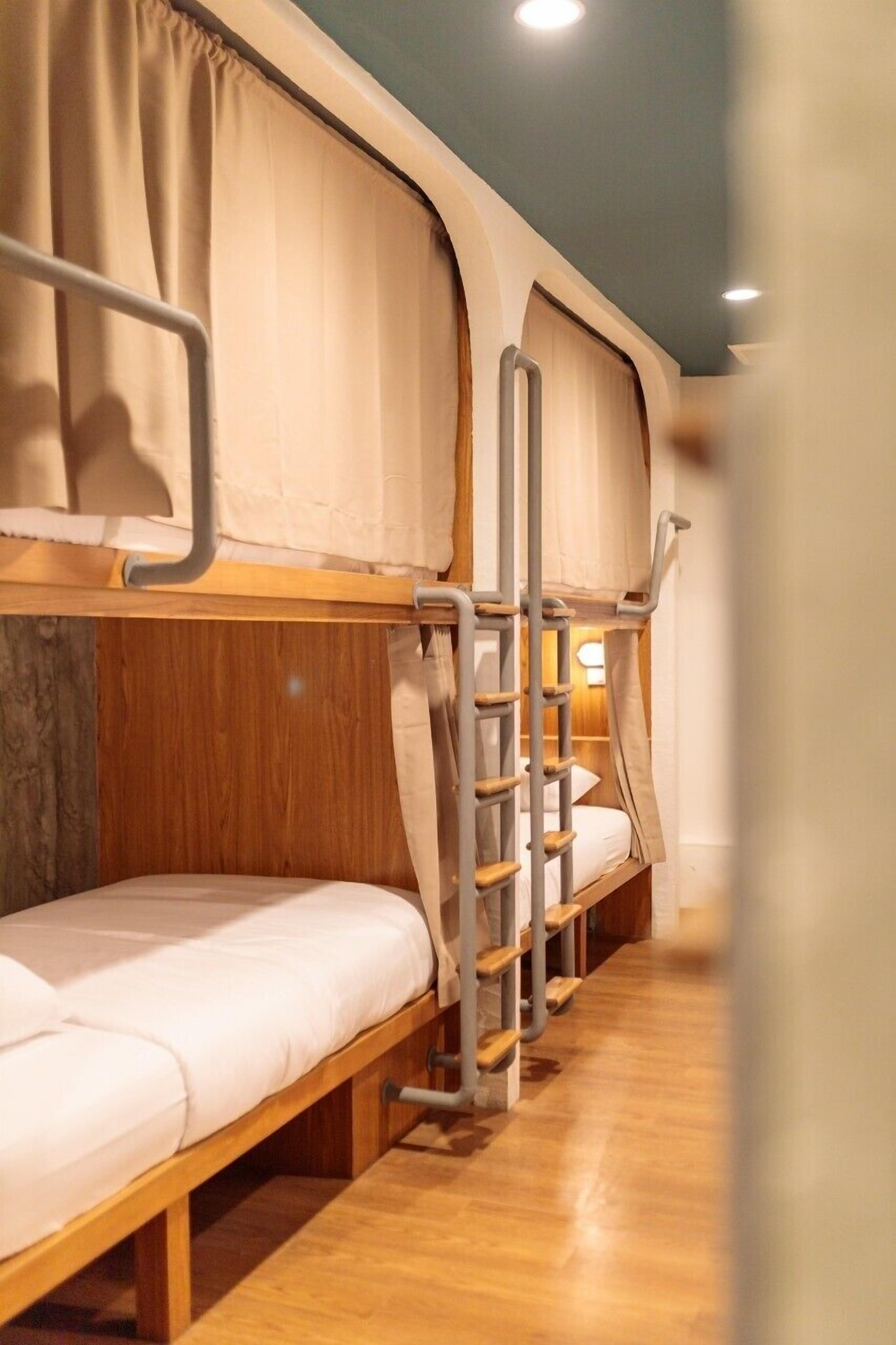 A bunk bed room with wooden frames and metal ladders.
