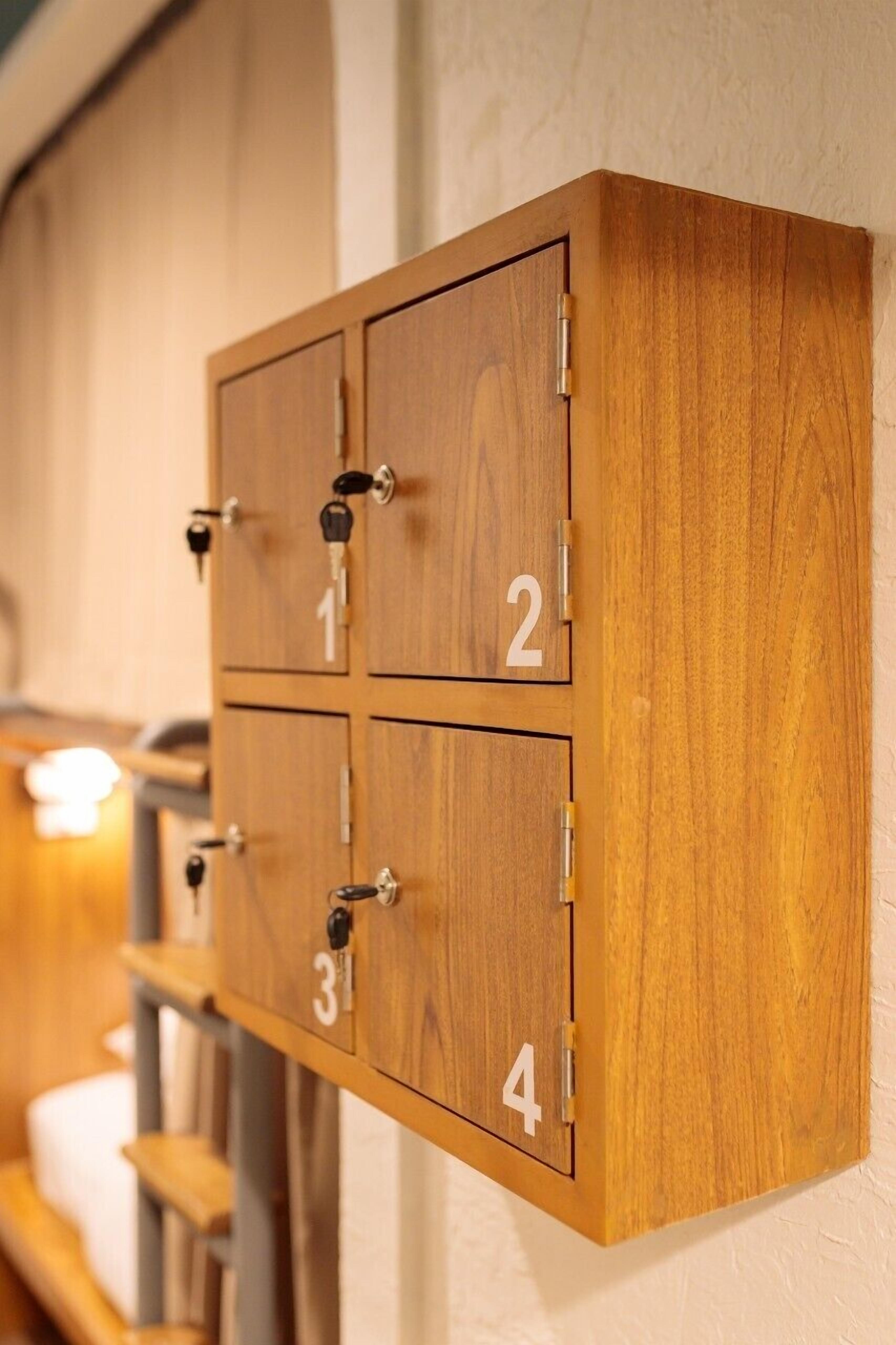 Un mobiletto contenitore in legno con quattro scomparti, ognuno contrassegnato con un numero da 1 a 4.