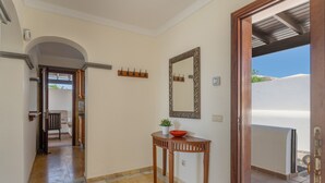 A hallway with a wooden table, a mirror, and a coat rack.