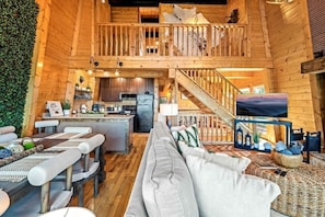 A spacious cabin with a loft bedroom, a dining area, and a kitchen. - Picadilly Point: VIEWS • Hot Tub • PS5 • Fire Pit (Gatlinburg)