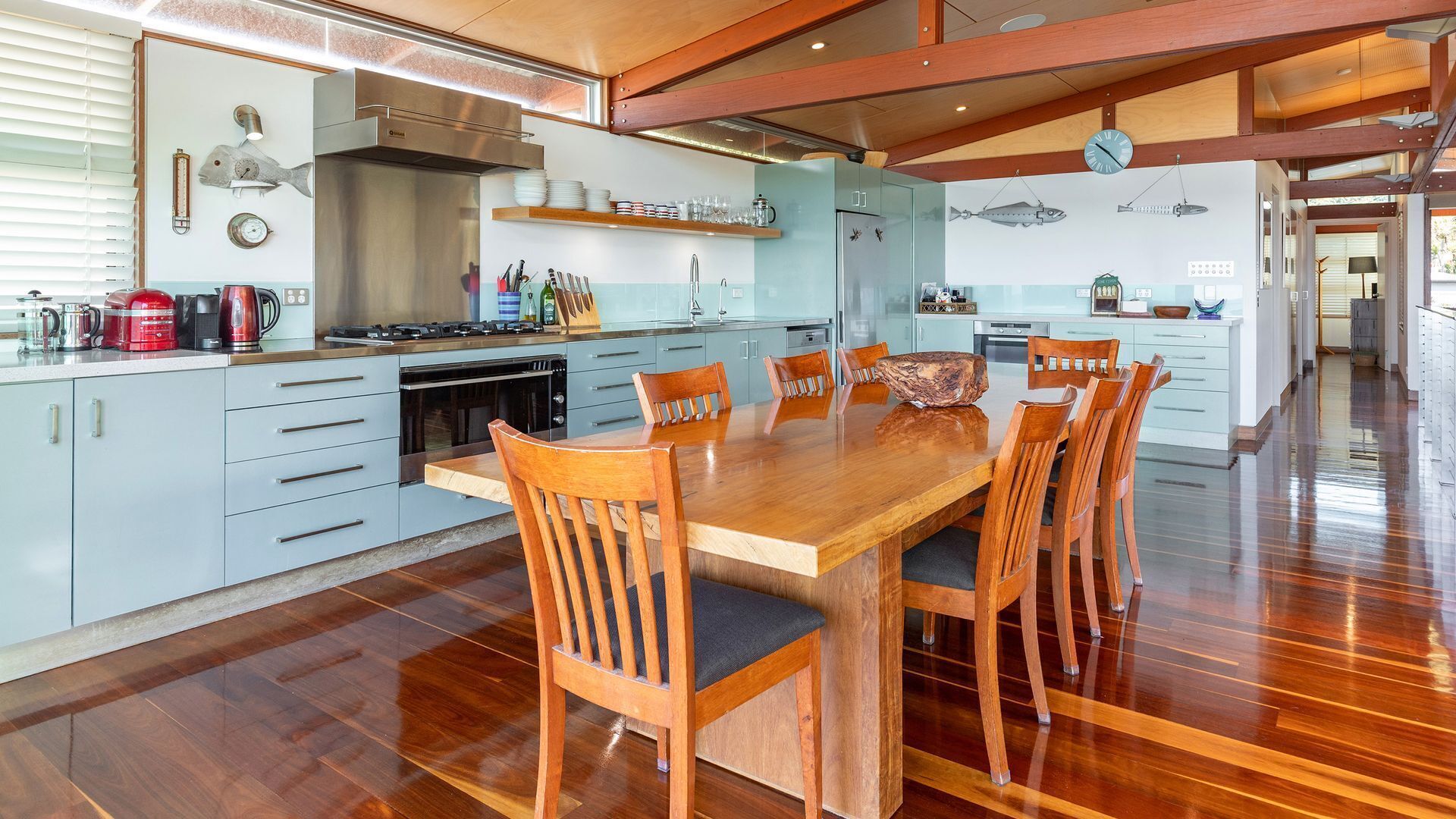 Une cuisine moderne avec un îlot central, des chaises en bois et une table à manger.