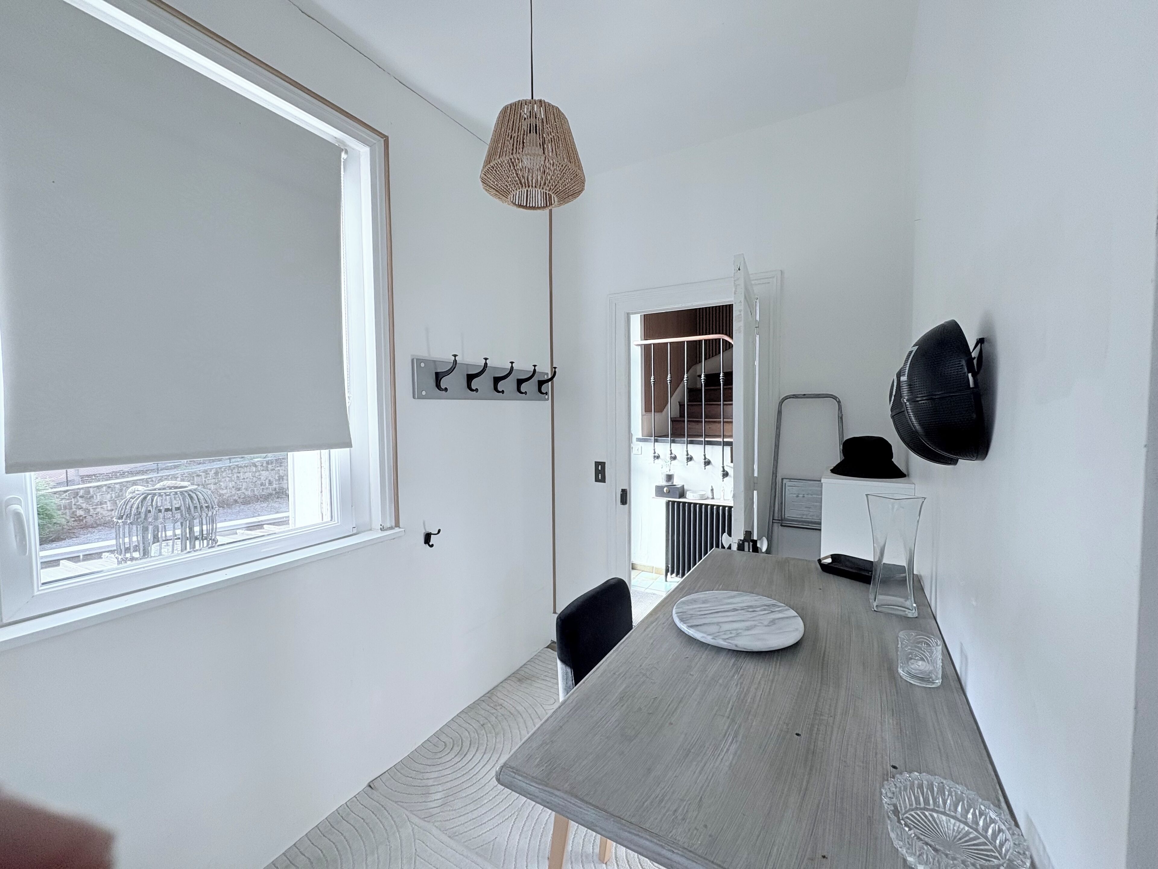 Une cuisine moderne dotée d’une grande fenêtre, d’une table à manger et d’un luminaire suspendu.