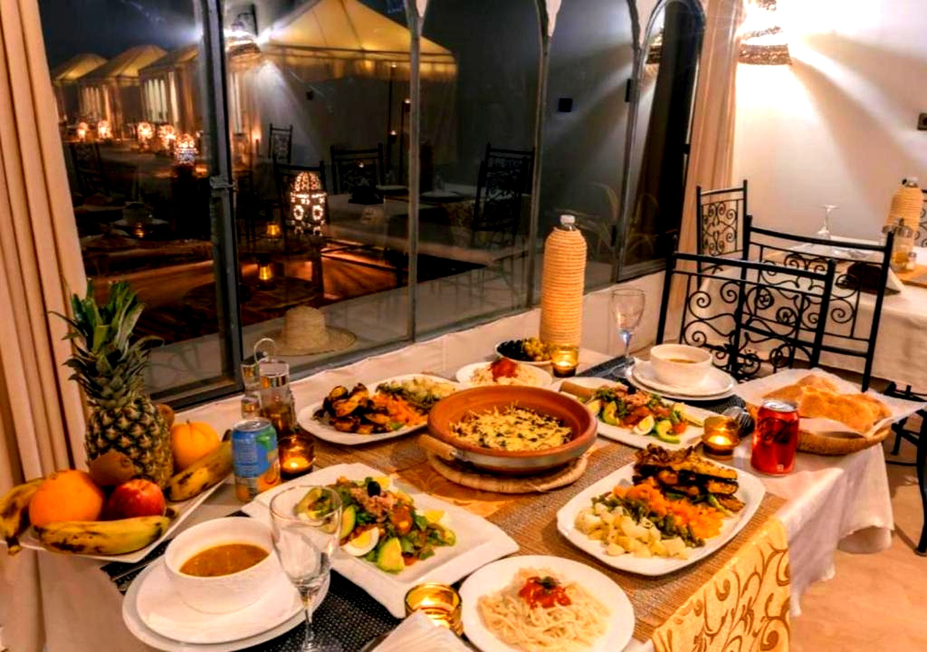 Una mesa de comedor preparada con varios platos, vasos y una piña.