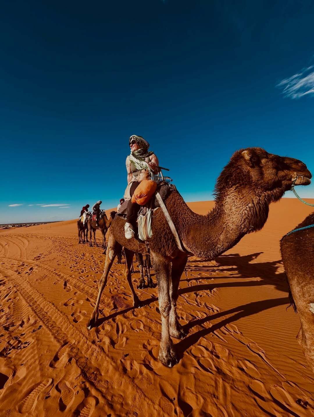 A desert landscape with camels and riders.