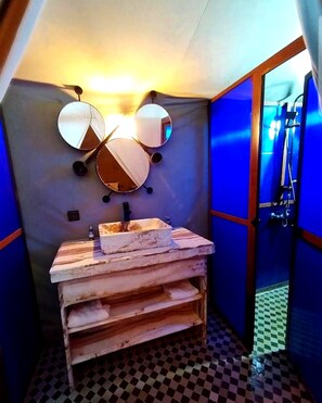 Casa de banho com lavatório, espelhos e chuveiro.