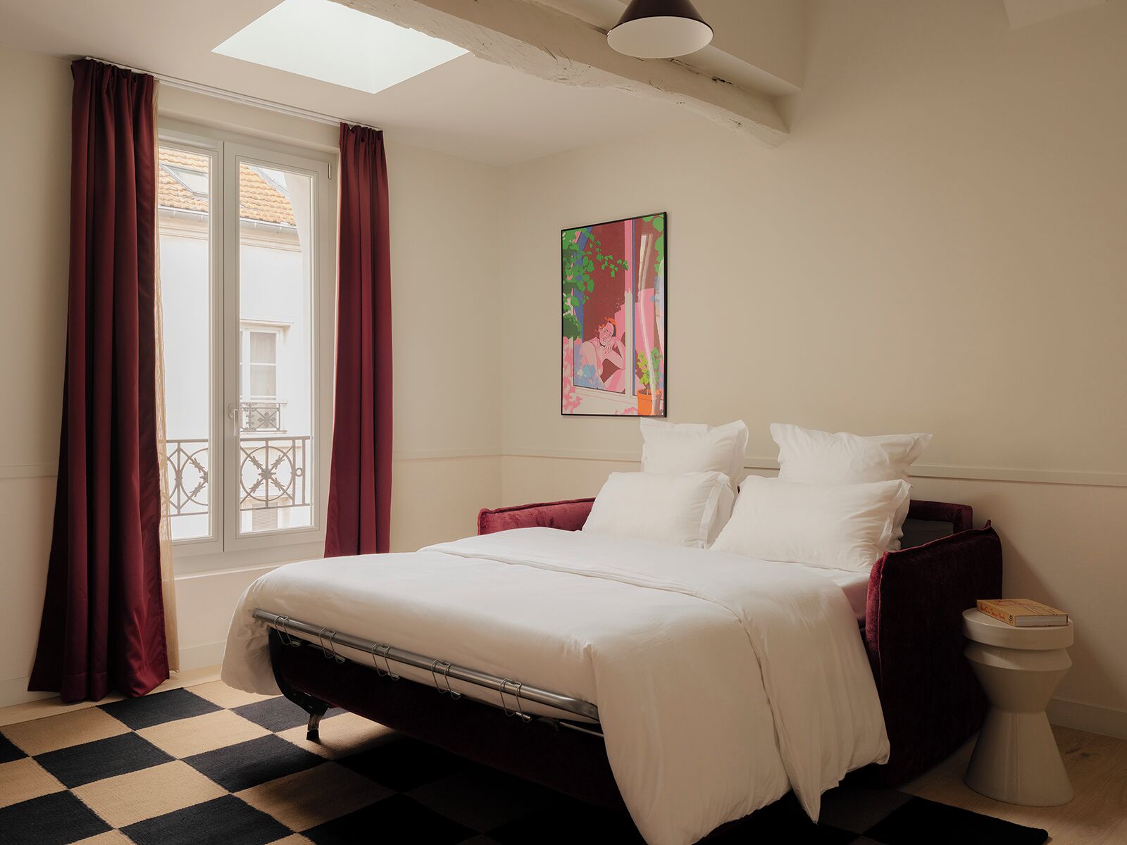 Um quarto com cama, janela com cortinas, um quadro na parede e chão xadrez.