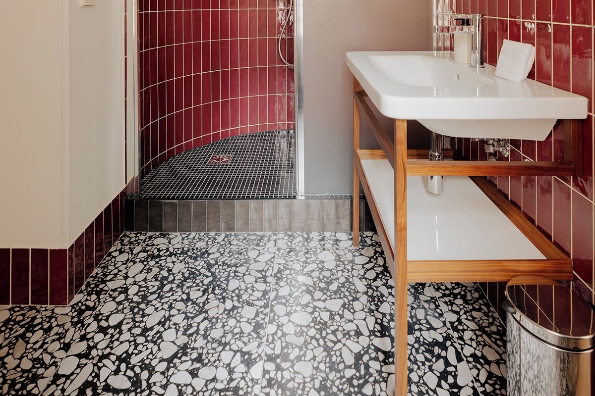 Un baño moderno con ducha de diseño, lavamanos blanco y espejo.