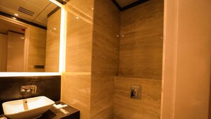 A bathroom with a sink, mirror, and shower. - MVR Grand Hotel (Kanpur)