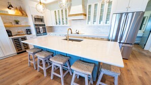 A modern kitchen with a large island, built-in appliances, and a wooden floor. - New Construction! Dogs OK, Elevator, Direct Beach Access! (Eastpoint)