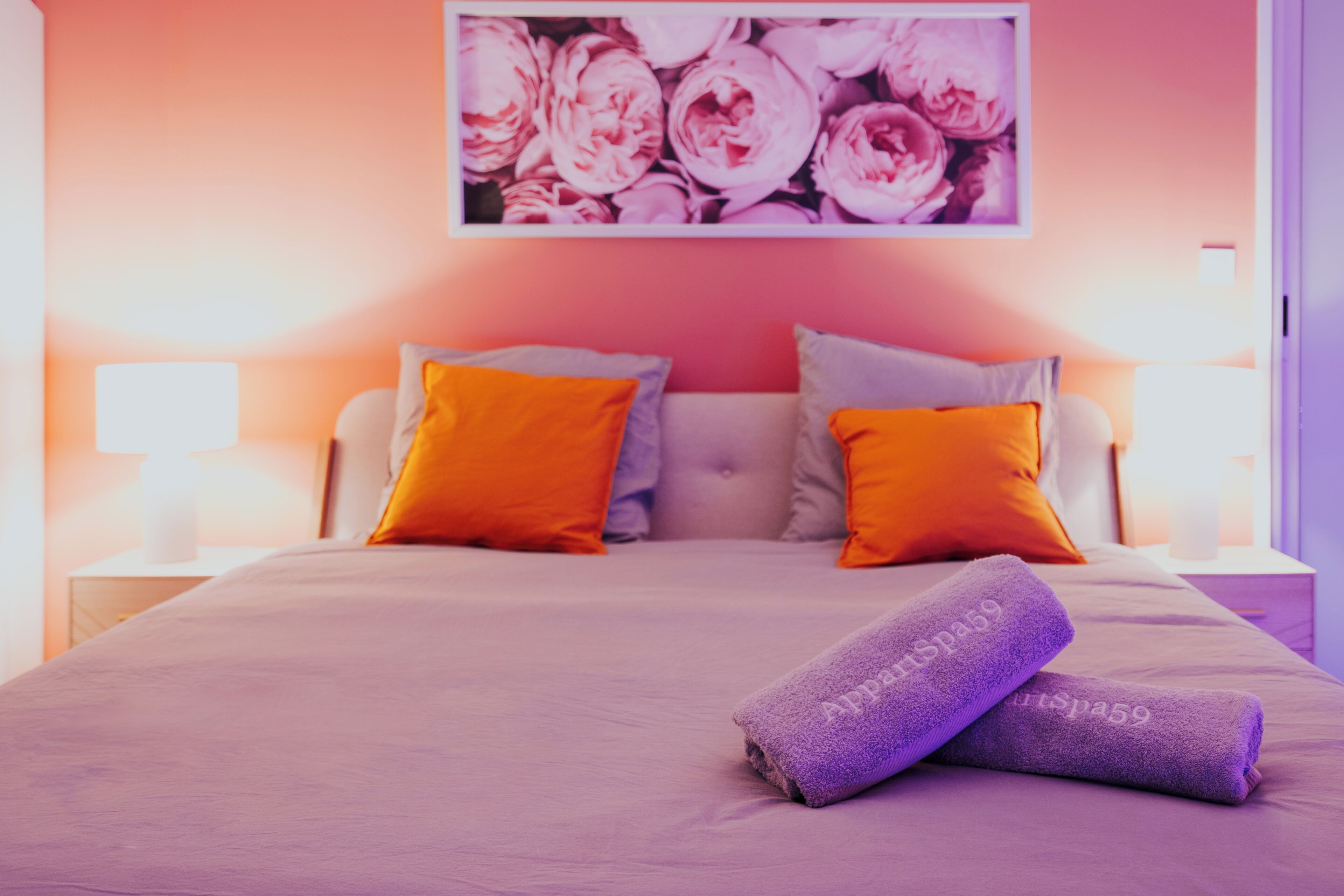 A bedroom with a bed, pillows, and a wall-mounted picture.