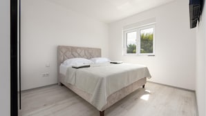 A bedroom with a bed, a window, and a wall-mounted air conditioner. - Cozy apartment in Vir with outdoor swimming pool (Vir)