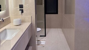 A modern bathroom with a large mirror, a white sink, and a toilet. - Amazing studio with charming view in charming Taif (Taif)