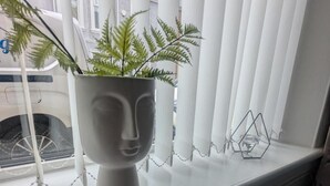 A potted plant on a windowsill with vertical blinds. - Charming Newcastle Home With Garden, Perfect for Families & Contractors (Jarrow)