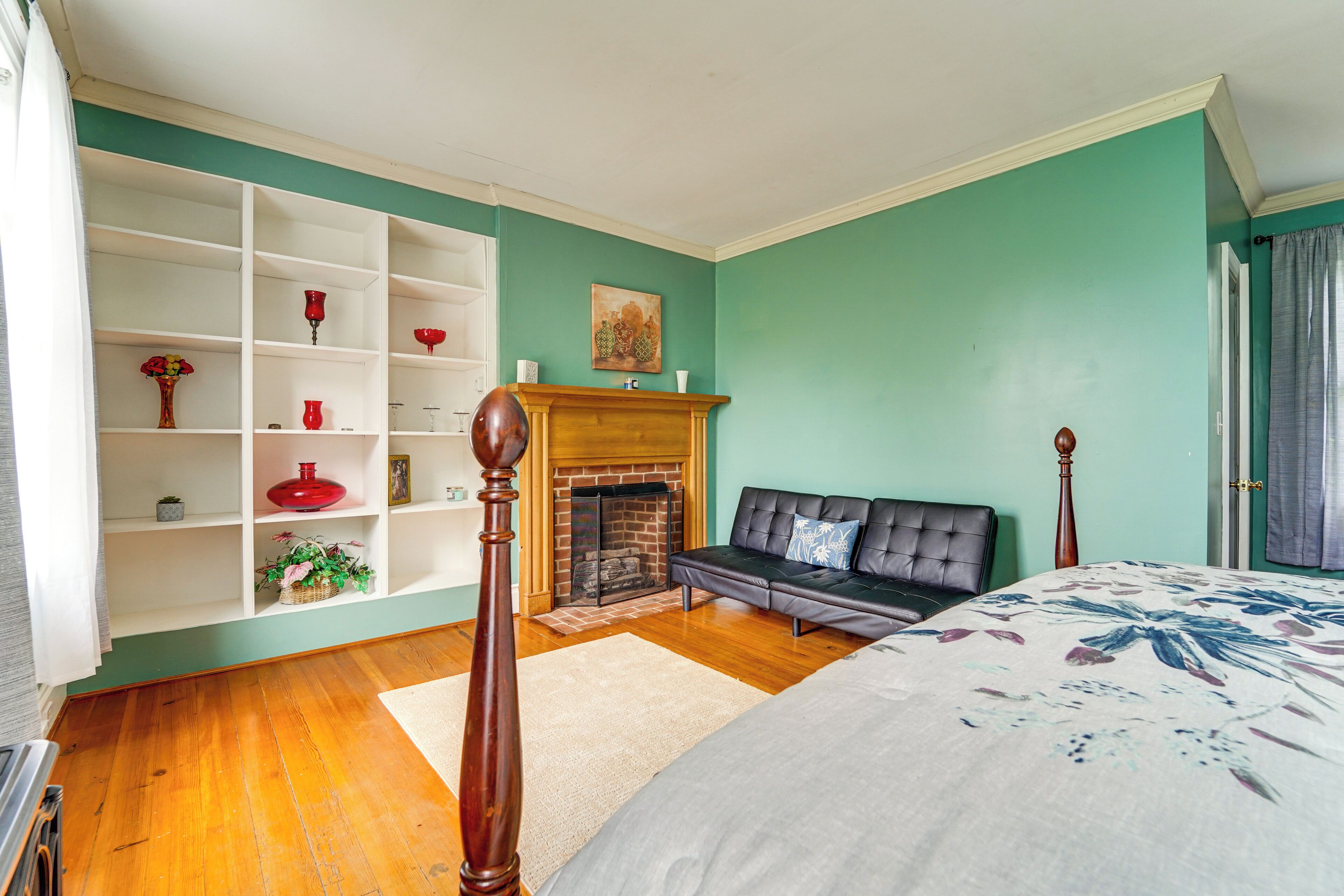 Une chambre avec une cheminée, un canapé, un lit et une bibliothèque.