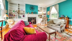 A spacious living room with a fireplace, a large bookshelf, and a cozy seating area. - Historic 30 Acre Retreat - Get Back to Nature (Ruckersville)