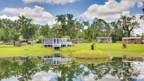 A lakeside property with a dock, a small building with a deck, and a larger building with a yellow door. - 'aunt Lucille's Place' - Cozy Cottage in Glenwood! (Glenwood)