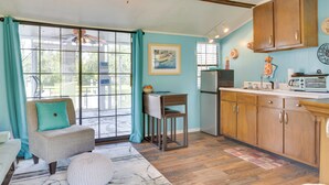 A kitchen with wooden cabinets, a dining area with a table and chairs, and a ceiling fan. - 'aunt Lucille's Place' - Cozy Cottage in Glenwood! (Glenwood)
