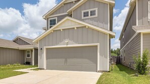 A two-story house with a garage, a small front yard, and a clear sky. - 4 Mi to Bear Creek Pioneers Park: NW Houston Home (Houston)