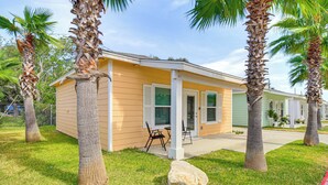 A single-story house with a porch, palm trees, and a grassy yard. - Fish & Swim On-site: Resort Retreat in Rockport! (Rockport)