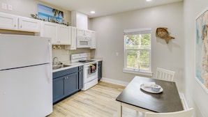A kitchen with white cabinets, a microwave, and a stove. There is a window with a view of greenery outside. - Fish & Swim On-site: Resort Retreat in Rockport! (Rockport)