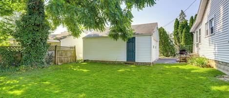 A residential property with a well-maintained lawn, a garage, and a wooden fence.