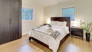 A bedroom with a wooden bed, two bedside tables, a nightstand, a wardrobe, and a window. - Pool + Lake Access, Yard: Poconos Family Getaway (East Stroudsburg)