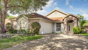 A two-story house with a garage, a large window on the first floor, and a brick entrance. - Jacksonville Family Home: Near Shopping & Dining! (Jacksonville)