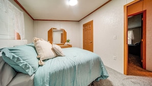 A bedroom with a bed, a nightstand, a mirror, and a door leading to another room. - 1 Mi to Lake Access: Erie Home w/ Private Backyard (Erie)