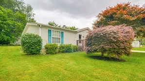 A single-story house with a front porch, surrounded by a well-maintained lawn and various shrubs. - 1 Mi to Lake Access: Erie Home w/ Private Backyard (Erie)