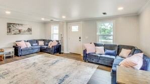 A spacious living room with a large sectional sofa, a coffee table, and a rug. - Walk to Winery! Home w/ Patio & Yard in Holt (Holt)