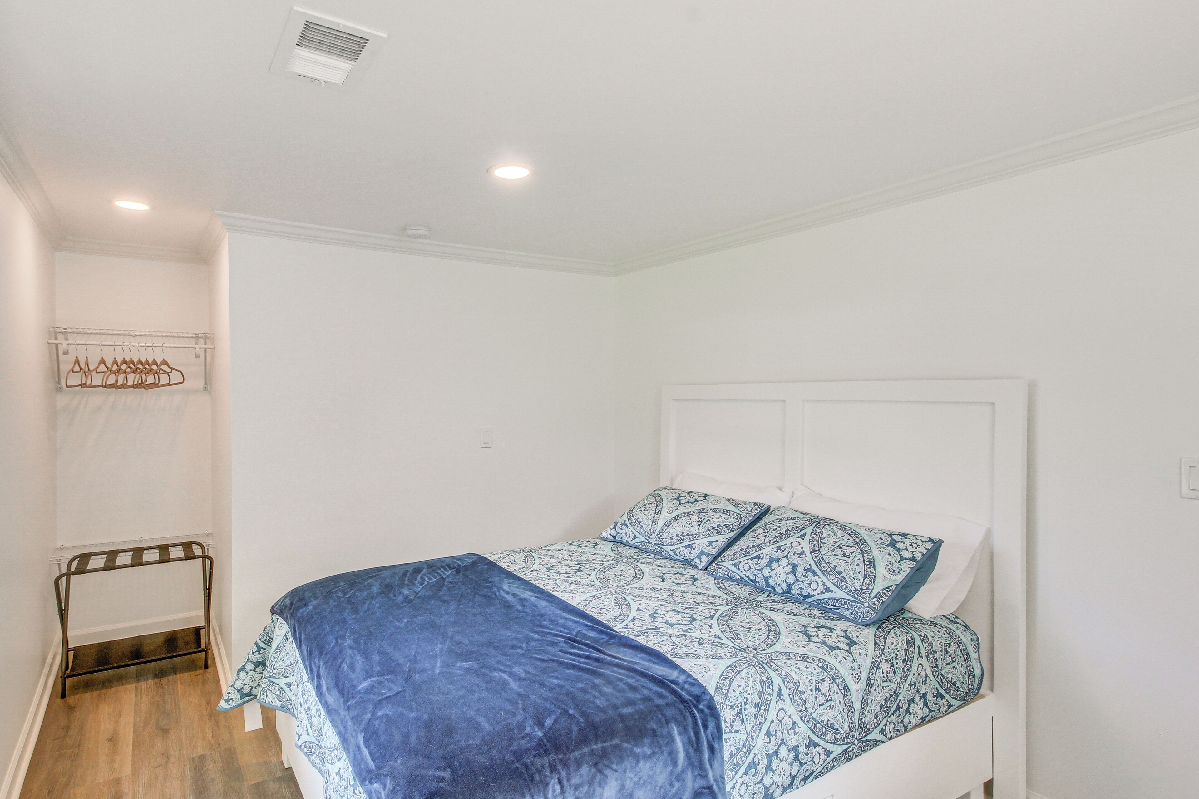 Un dormitorio con cama, perchero y radiador.