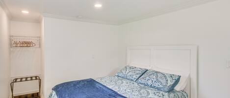 Un dormitorio con cama, perchero y radiador.