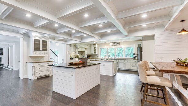 A spacious kitchen with a large island, white cabinetry, and a wooden floor. - 7,100 Sq Ft Retreat w/ Gazebo + Koi Pond in Wayne! (Wayne)