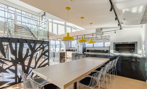 A modern kitchen with a large island, stainless steel appliances, and a mezzanine with a staircase. - Comfortable and Complete Stay in Downtown Curitiba - ECL (Curitiba)