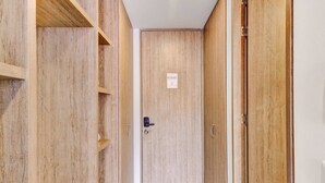 A wooden wardrobe with a door, a shelf, and a small sign on the door.
