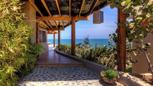 A covered wooden walkway leading to a beach with a view of the ocean. - w Enjoyable 4BR w Pool in M Ncora (Máncora)