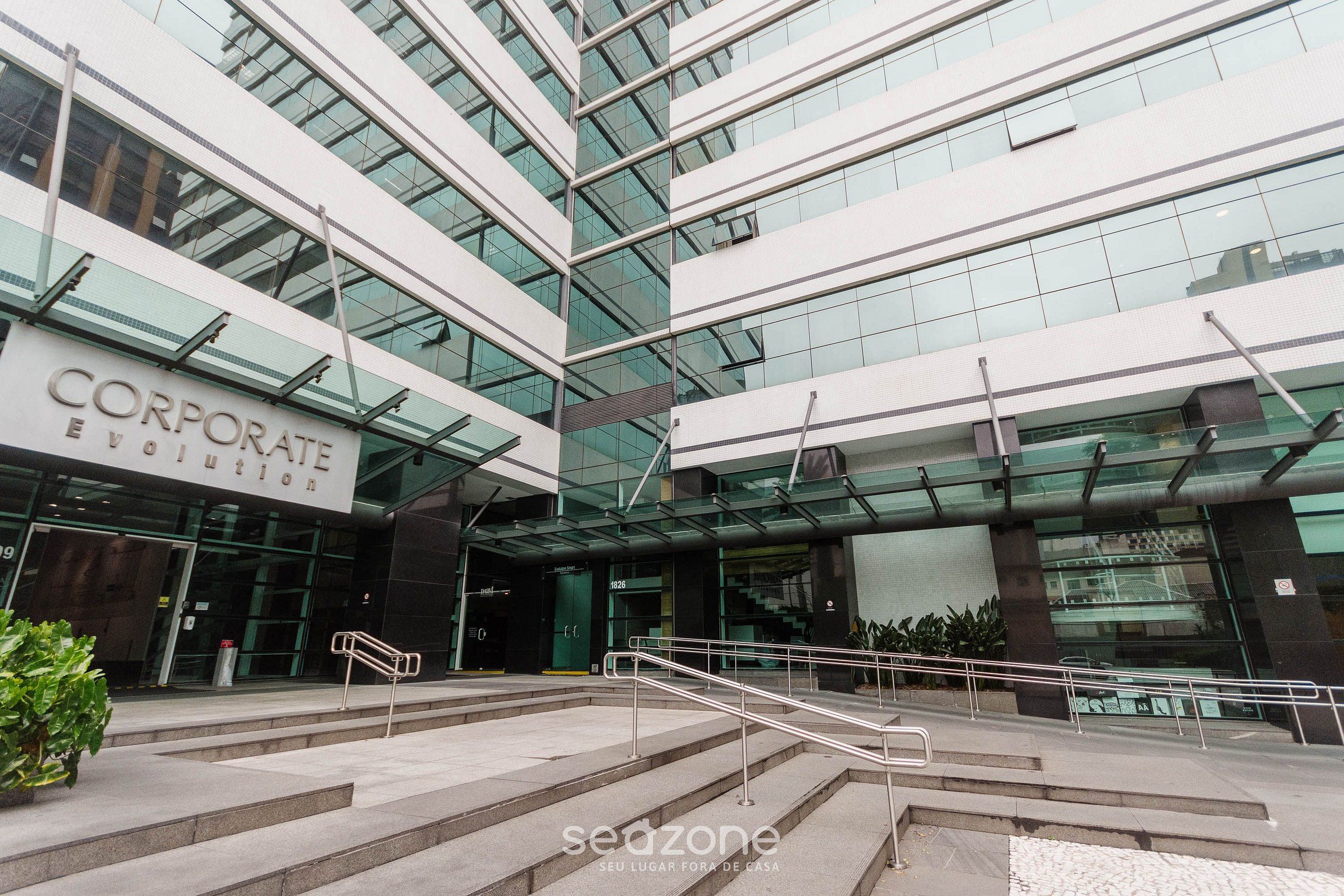 A modern corporate building with a glass facade, a staircase leading to the entrance, and a sign reading "CORPORATE EVOLUTION".