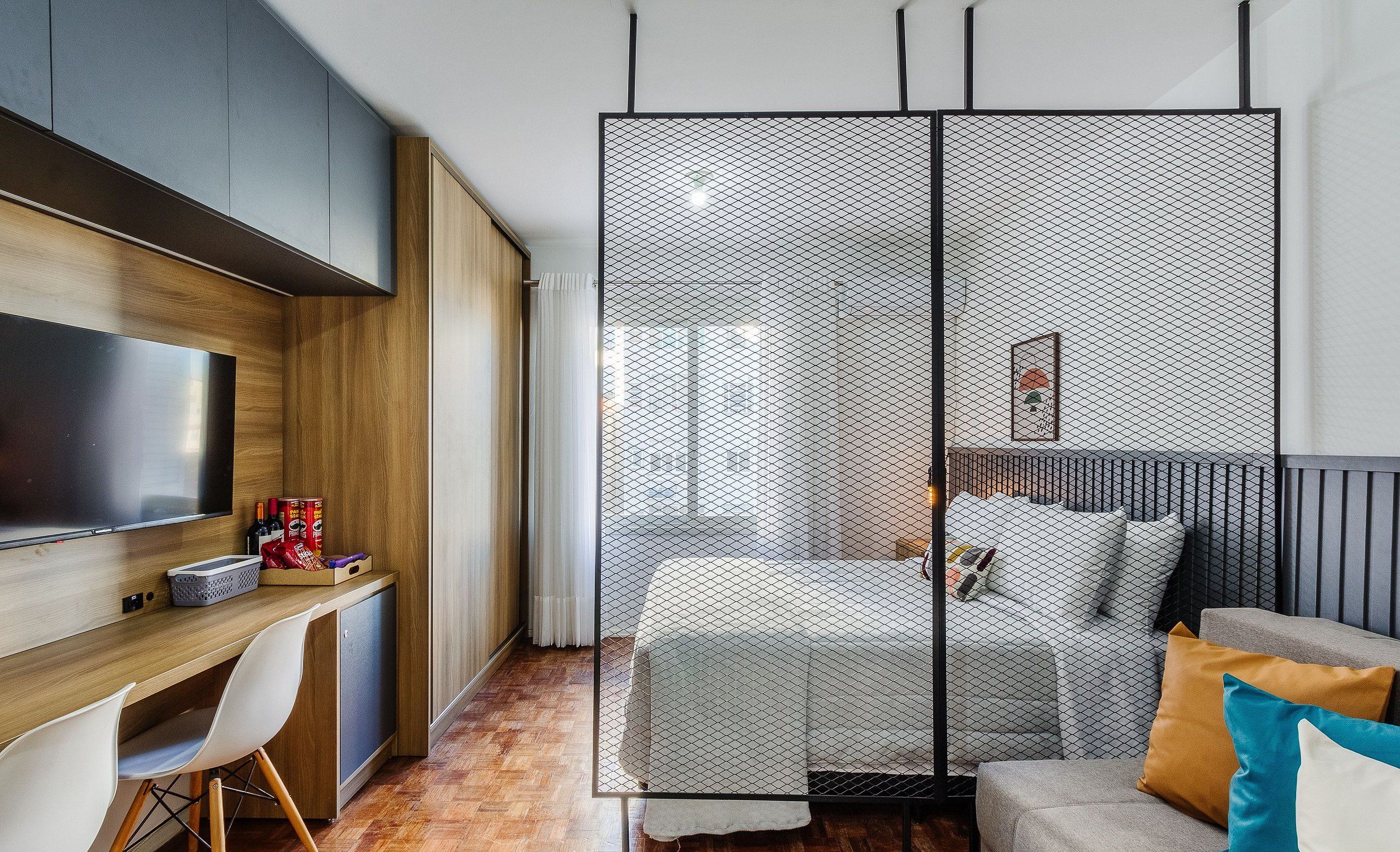 Une chambre à coucher moderne, avec un lit, un bureau et un téléviseur.