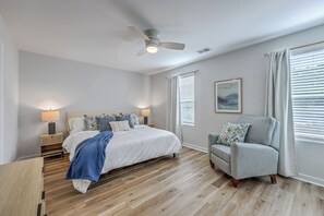 A bedroom with a bed, bedside tables, a chair, a ceiling fan, and a window with blinds. - Charming New Build 3 Bedroom in Hanahan! Close to everything! (Hanahan)