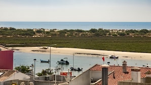 A coastal view with boats on a sandy beach and a clear sky.